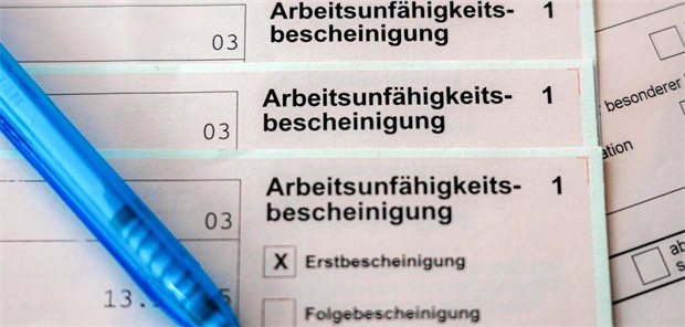 Pflegeberufe besonders betroffen: Hitze führt zu Anstieg von Krankmeldungen Mehrere Exemplare einer Arbeitsunfähigkeitsbescheinigung liegen übereinander, daneben ein Kugelschreiber.