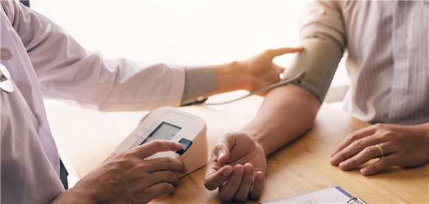 Behandlungsresistente Hypertonie: Vier-in-Eins-Kapsel schlägt Dreier-Einzelkombi Nahaufnahmes eines Arzt der mit einem Blutdruckmessgerät den Blutdruck des Patienten misst.