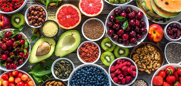 Vegetarische Ernährung und Krebsrisiko: Nicht immer ist pflanzlich besser! Auswahl an gesunden pflanzlichen Lebensmitteln: Superfoods, verschiedene Obstsorten und Beeren, Nüsse und Samen.
