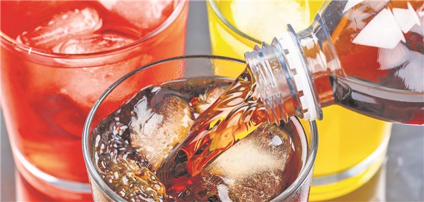 Warum die Zuckersteuer gerade so viele Fürsprecher hat Gläser mit bunten Limonaden; in ein Glas wird eine Limonade aus einer Flasche gefüllt.