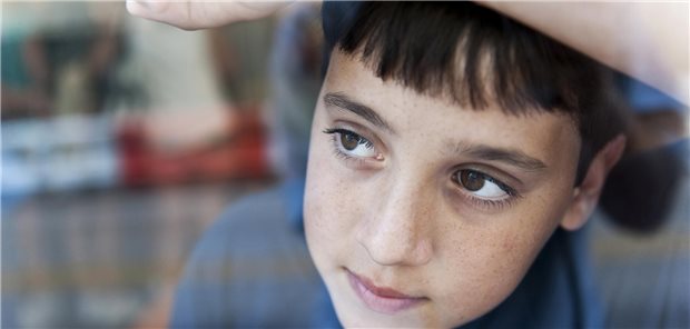 Autismus-Spektrum-Störung: Prävalenz bei Mädchen höher als bisher angenommen Ein Kind sieht gedankenverloren aus einem Fenster.