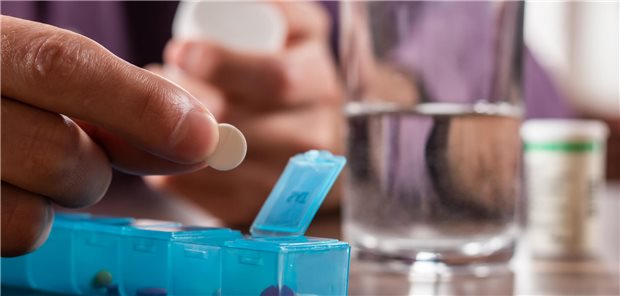 Jeder Vierte erhält offenbar mindestens ein inadäquates Medikament im Alter Nahaufnahme einer männliche Hand, die die Tagesdosen an Vitaminen, Medikamenten, Tabletten und Nahrungsergänzungsmitteln in eine Tablettenbox füllt.