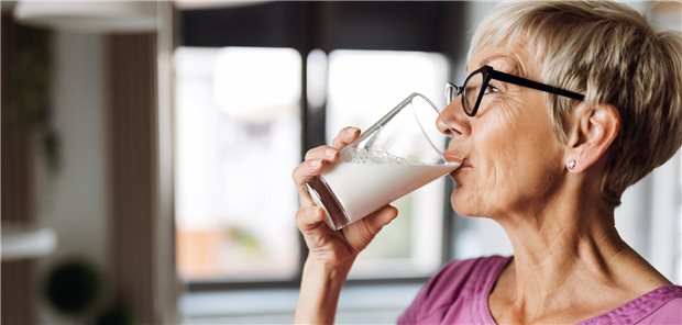 Eine ältere Frau trinkt ein Glas Milch