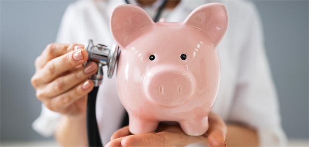 Was sich auch ändert: Weniger Prävention, aber höhere Zuzahlungen Eine Ärztin untersucht ein Sparschwein.