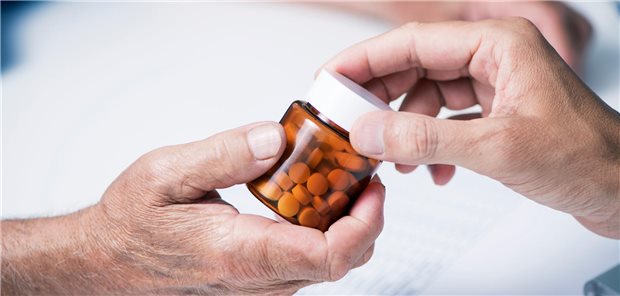 Antikoagulation nach VTE: Länger könnte besser sein Nahaufnahme eines Arztes, der einem älteren Patienten eine Flasche mit seinen Tabletten übergibt.