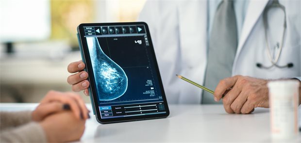 HER2-positiver Brustkrebs: Weniger Chemotherapie möglich Ein Arzt zeigt einer Frau auf seinem Tablet einen Scan ihrer Brust.