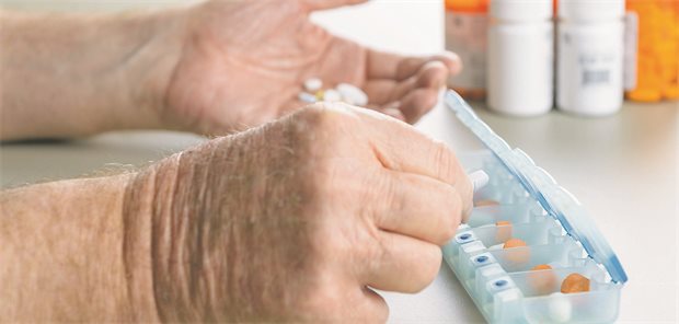 Neuer Online-Meldebogen für unerwünschte Arzneimittelwirkungen Mann vor Pillendose mit vielen Tabletten.