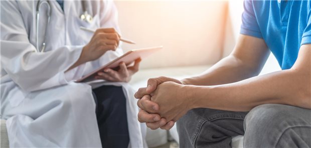 Sexualanamnese in der Hausarztpraxis: Worauf zu achten ist Eine Ärztin führt ein vertrauliches Gespräch mit einem jungen Mann.