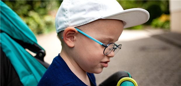 Kind mit Brille im Kinderwagen