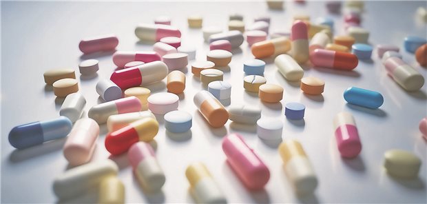 Intensivierung bei therapieresistenter Hypertonie: Wie vorgehen? Sehr viele unterschiedliche Tabletten liegen auf einem weißen Tisch.