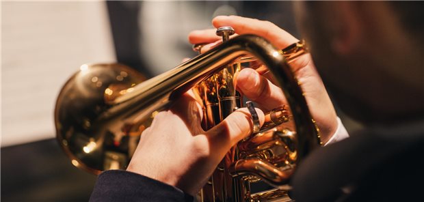 Ihr Patient ist Musiker? Was dann relevant werden könnte Blick über die Schulter eines Trompeters, der ein Konzert spielt.