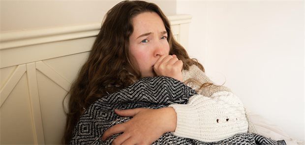 So unterscheiden sich primäre und sekundäre Immundefekte Eine Frau sitzt im bett und hustet.