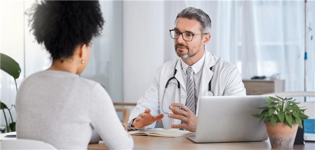 Patient mit Mundgeruch: Wie Sie das im Patientengespräch ansprechen Ein Arzt spricht mit einer Patientin