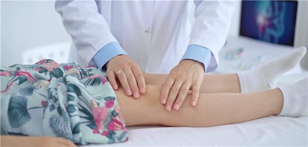 Knieschmerzen bei Kindern: Wann es mehr als nur Wachstumsschmerz ist Ein Arzt untersucht das Knie eines Mädchens.