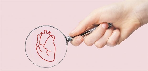 Magnetokardiographie zur Kardiomyopathie-Diagnostik? Jemand richtet eine Lupe auf die Abbildung eines menschlichen Herzes.
