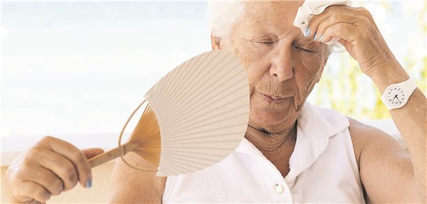Sommerhitze: Das ist wichtig bei älteren Patienten Ältere Frau versucht, sich mit einem Fan abzukühlen.