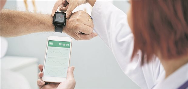 Krebsmedizin der Zukunft: Potenziale und Probleme bei Gesundheitsdaten in Deutschland Ein Smartphone wird mit einer Smartphone-App synchronisiert von einer Ärztin.