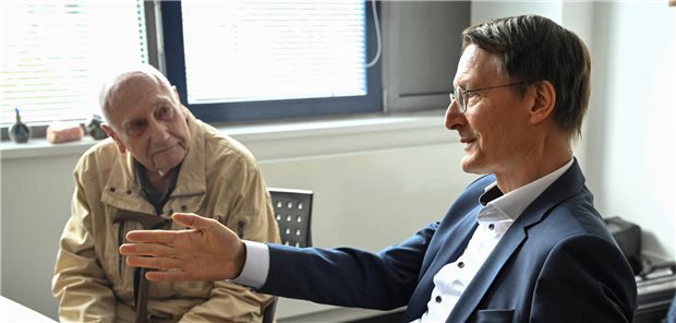 Coaches in Rheinland-Pfalz unterstützen Senioren mit der ePA Karl Lauterbach erklärt einem älteren Patienten etwas Technisches.