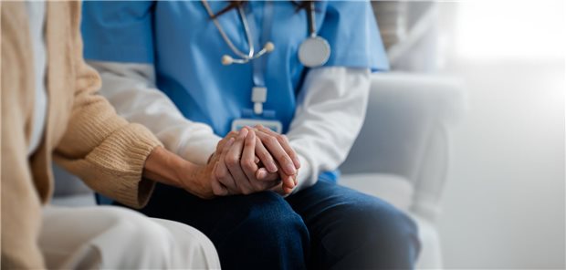 Delegation: Produktivitätsgewinn für die Praxis – Versorgungssicherheit für die Region Eine Person mit Sthetotskop um den Hals hält die Hand einer Patientin.