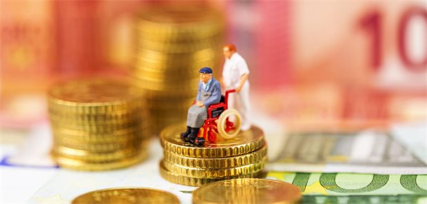 „Dammbruch“: PKV-Verband warnt vor Finanzausgleich in der Pflege Spielfiguren auf Geldmünzen und Geldscheinen.