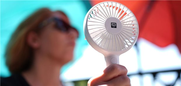 Unsere Beiträge zum Thema Hitze in der Übersicht Eine Frau hat einen kleinen Ventilator in der Hand.