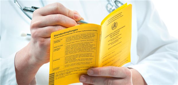 Diabetes: Grippeimpfung schützt das Herz! Ein Arzt füllt einen internationalen Impfpass aus.