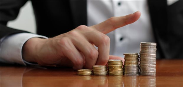 KBV-Chef Andreas Gassen bleibt der bestbezahlte KV-Funktionär Das Foto zeigt eine Hand, dessen Finger schräg nach oben zeigt. Daneben liegen Geldmünzen auf einem Tisch.