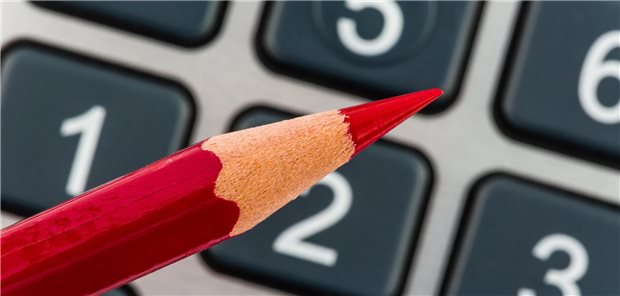 Wegen Spargesetz: KV Berlin ändert Honorarverteilung und streicht Förderung Ein roter Stift vor einem Taschenrechner.