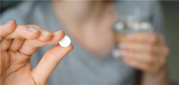 Wohl selten infektiöse Komplikationen nach Kortikoidgabe in der HNO-Medizin Nahaufnahme der Hand einer Frau die eine runde weiße Tablette zwischen Daumen und Zeigefinger hält.