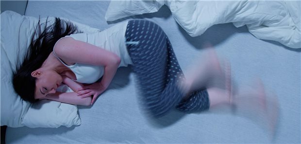 Restless-Legs-Syndrom: Mit 5 Kriterien zur Diagnose Frau mit Restless-Legs-Syndrom liegt im Bett und wackelt mit den Beinen.