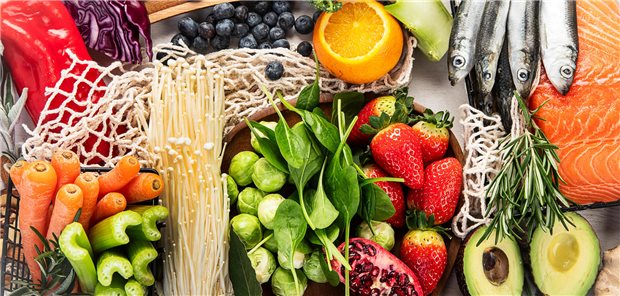 Morbus Crohn bei Kindern: Remission auch ohne enterale Ernährungstherapie erreichen Viele verschiedene Lebensmittel auf einem Tisch: Karotten, Sellerie, Rosenkohl, Erdbeeren, Avocado, Oilze, Blaubeeren, Paprika und weiteres.