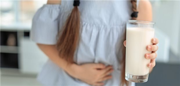 Milcheiweißallergie als Risikofaktor für Otitis media bei Kindern Ein Mädchen mit einer Kuhmilchallergie, dass aufgrund des Konsums von Kuhmilch Bauchschmerzen hat.