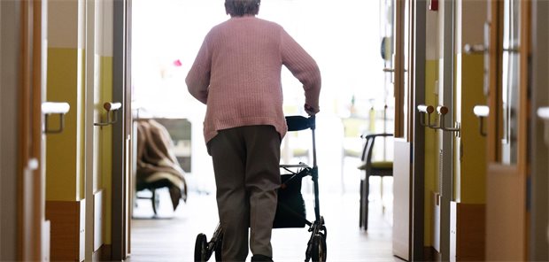 „Am pflegepolitischen Scheideweg“: Koalition ringt um die Pflegereform Eine Pflegeheimbewohnerin läuft mit einem Rollator durch ein Pflegeheim.