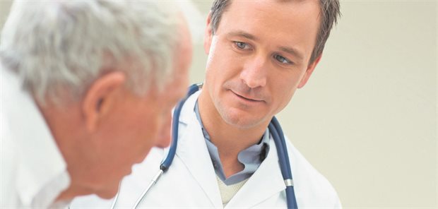 Wie Sie Schmerzen bei Demenz-Patienten erkennen Ein arzt schaut einem alten Patienten genau ins Gesicht