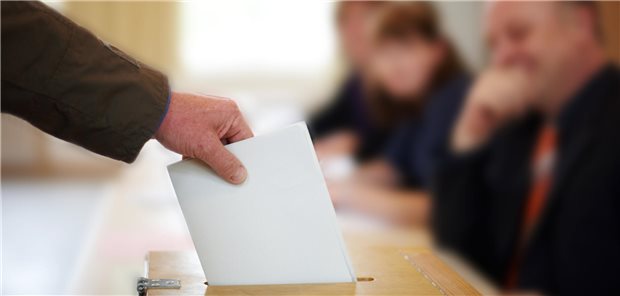 Nur wer demokratisch lebt und handelt, kann die Medizin stärken Eine Hand steckt einen Wahlumschlag in eine Urne.
