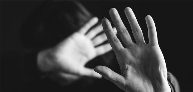 Das ist wichtig bei der Erstversorgung von Frauen nach sexualisierter Gewalt Nahaufnahme einer Frau, die schützend ihre Hände abwehrend vor ihrem Körper und Gesicht hält.