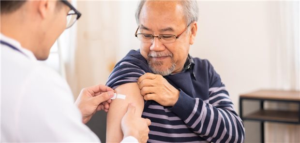 Demenzschutz durch Zosterimpfung: Studie liefert erneut Hinweise Ein Arzt klebt einem älteren Herrn ein Pflaster auf den Arm, wo der Mann geimpft wurde.