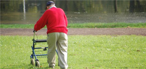 Ein alter Mann geht mit Rollator spazieren