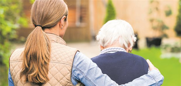 Angehörigen-Verein fürchtet Verwerfungen durch geplante Pflegereform Eine junge Frau begleitet eine ältere Dame beim Spaziergang im Park.