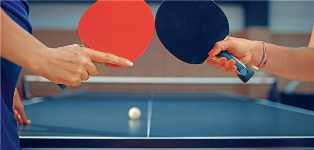 „Wir denken Primärversorgung oft noch als Ping Pong zwischen Arztpraxen“ Tischtennisspielerinnen tippen zum Gruß vor dem Spiel ihre Schläger aneinander.