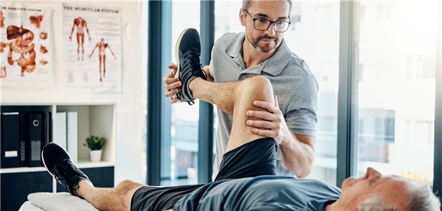 „Kostensteigerungen ohne mehr Qualität“: AOK reitet Attacke gegen Blankoverordnung Das Foto zeigt einen Physiotherapeuten bei der Behandlung eines älteren Patienten.