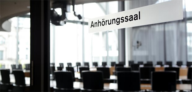 GKV-Sparpaket in der Anhörung: Bedeuten die Korrekturen tatsächlich Verbesserungen? Das Foto zeigt auf einer Glastür das Schild "Anhörungssaal".