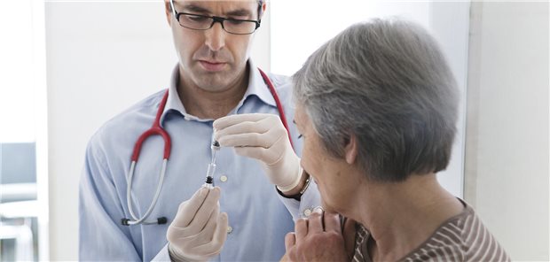 Baden-Württemberg: Impfhonorar steigt zum Monatswechsel um 8,0 Prozent Arzt hält neben Patientin Spritze senkrecht