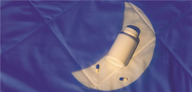 Kardiologen warnen: Melatonin-Einnahme mit Herzinsuffizienz assoziiert Eine Tablettendose liegt auf dem Bett. Ein Lichtkegel in der Form des Mondes scheint darauf.
