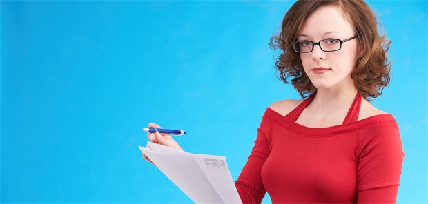 Praxisbegehung angekündigt? Die wichtigsten Tipps zur Vorbereitung Frau mit Unterlagen und Stift schaut streng