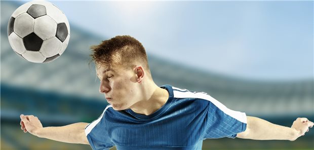 Was Kopfbälle fürs Demenzrisiko bedeuten Ein Fußballspieler macht einen Kopfball.