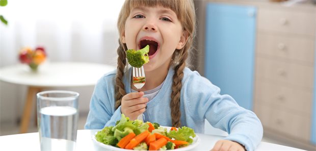 Vegetarische und vegane Ernährung bei Kindern mit Vorerkrankungen Eine Mutter hat ihre Tochter am Schoß und sitzt in der Sprechstunde eines Arztes.