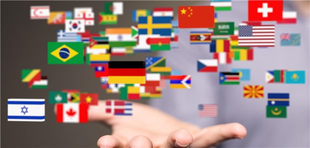 Darmkrebsvorsorge: So werden Menschen mit Migrationshintergrund erreicht Ein mann hält seine Hand offen. Aus der Hand kommen die Flaggen verschiedener Länder geflogen.