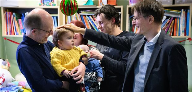 Karl Lauterbach streicht ein Kind bei einem Rundgang durch das Deutsche Herzzentrum der Charité in Berlin über den Kopf.