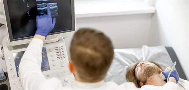 Herzkreislauf: Gehört der Ultraschall in die Untersuchung zur Früherkennung? Ein Arzt führt eine Carotis-Sonografie bei einem jungen Mann durch.